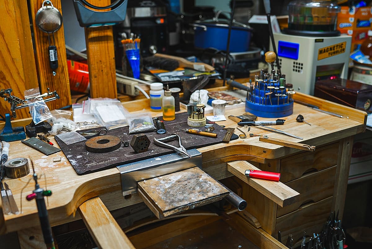 The jewelry repair bench inside Frog's Pawn, staking set and hand tools laid out
